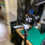 Camera shoots through the glass and because of angle - it won't see the teleprompter type.